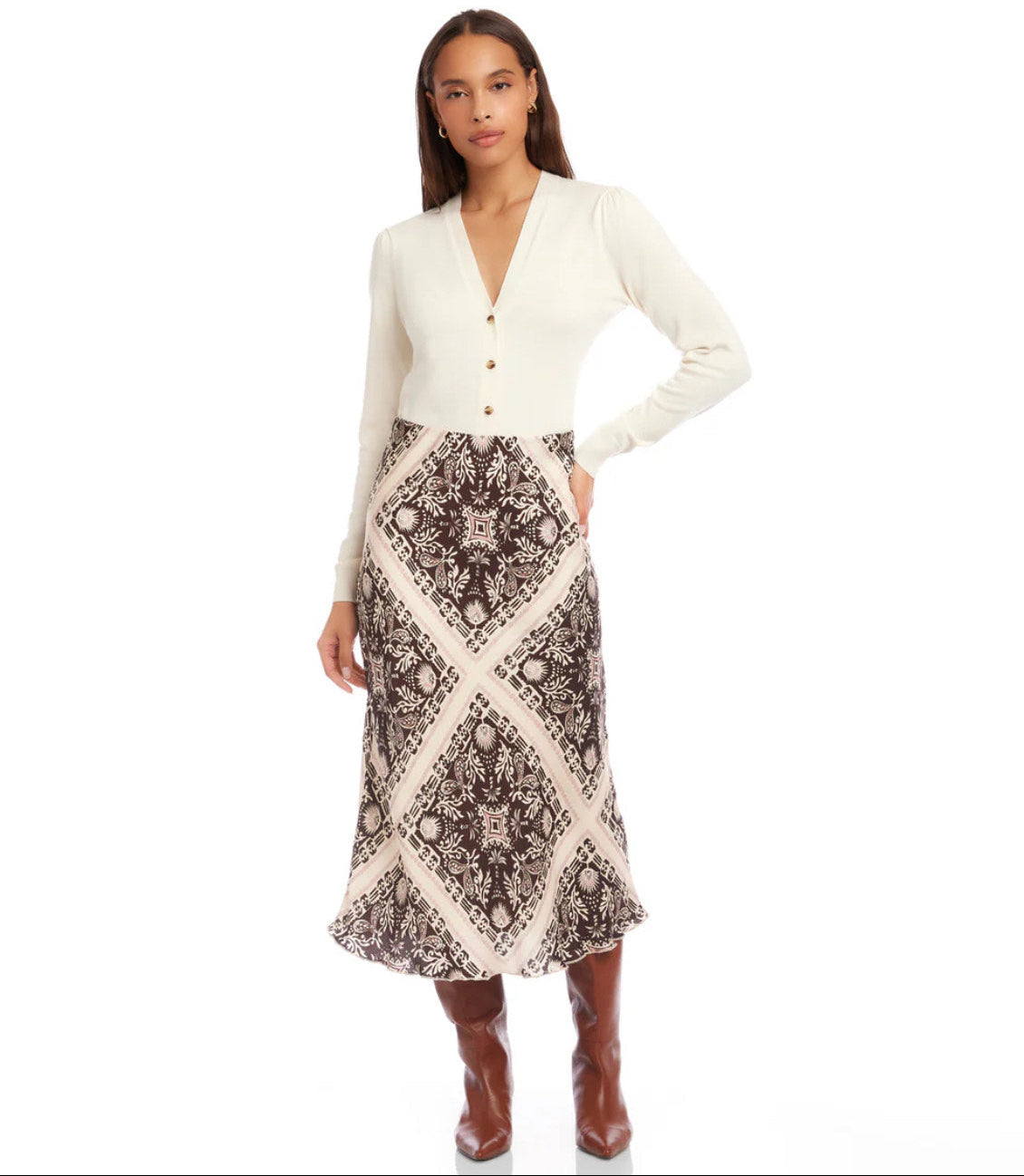 Woman wearing a white cardigan and patterned skirt on a white background