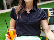 Load image into Gallery viewer, Model wearing Criquet - Women&#39;s Short Sleeve Performance Polo in Black.
