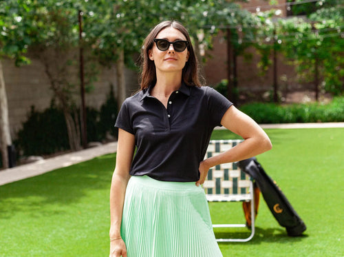 Model wearing Criquet - Women's Short Sleeve Performance Polo in Black.