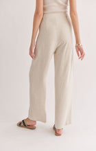 Load image into Gallery viewer, Model wearing Sadie &amp; Sage - La Luna Pleated Trousers in Oatmeal - back.
