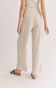 Model wearing Sadie & Sage - La Luna Pleated Trousers in Oatmeal - back.