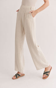 Model wearing Sadie & Sage - La Luna Pleated Trousers in Oatmeal.