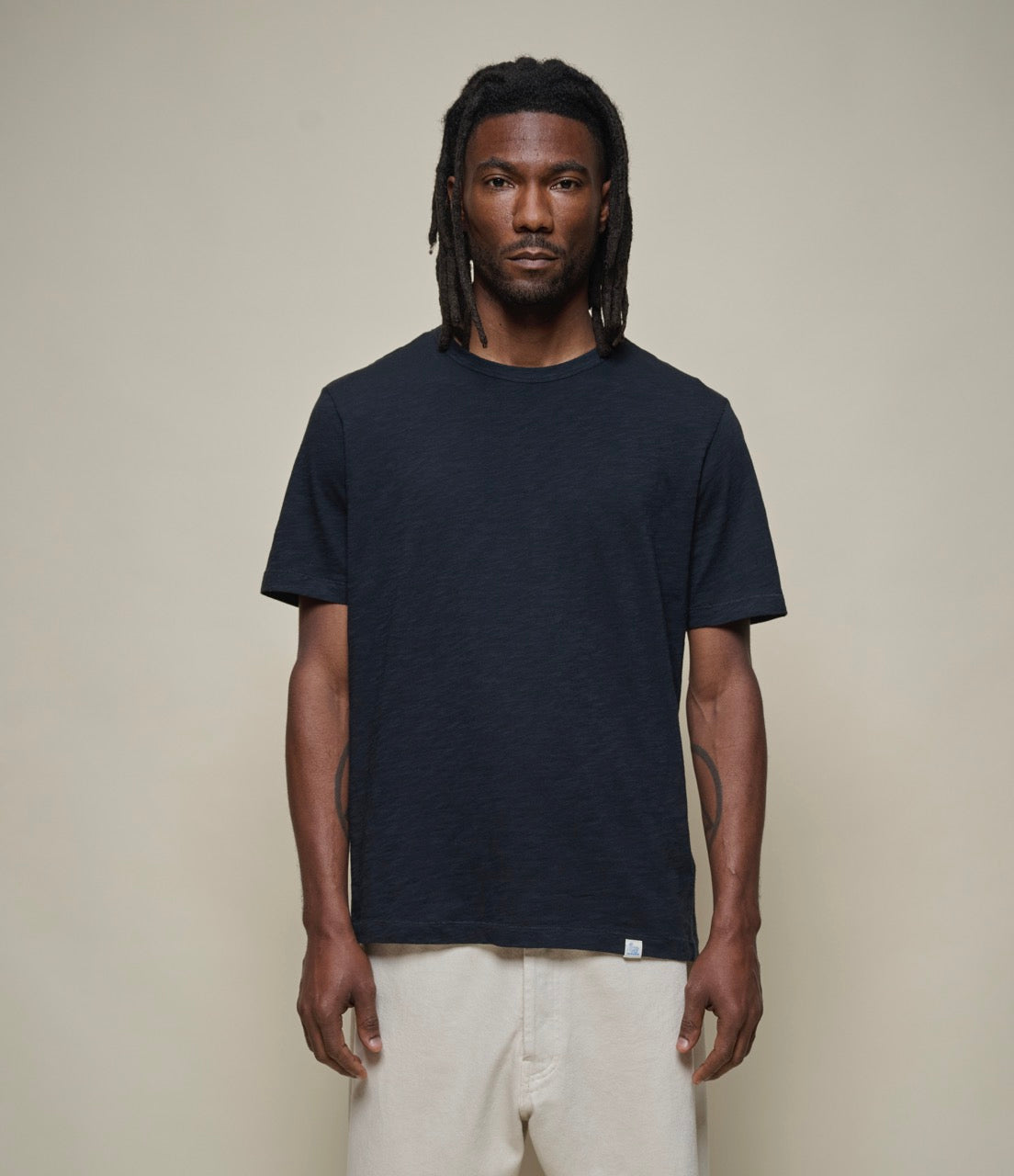 Model wearing Merz B. Schwanen - Good Basics Unisex T-shirt in Deep Black.