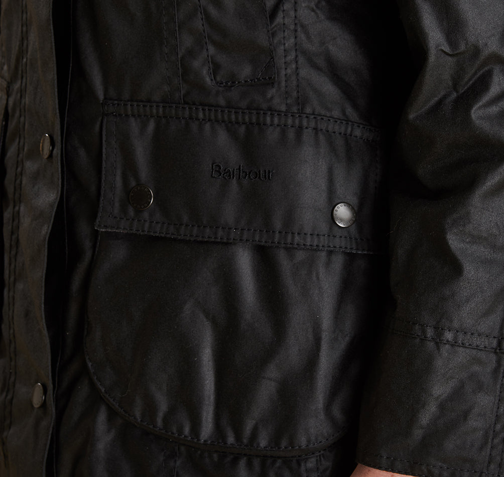Model wearing Barbour Beadnell wax jacket in black.