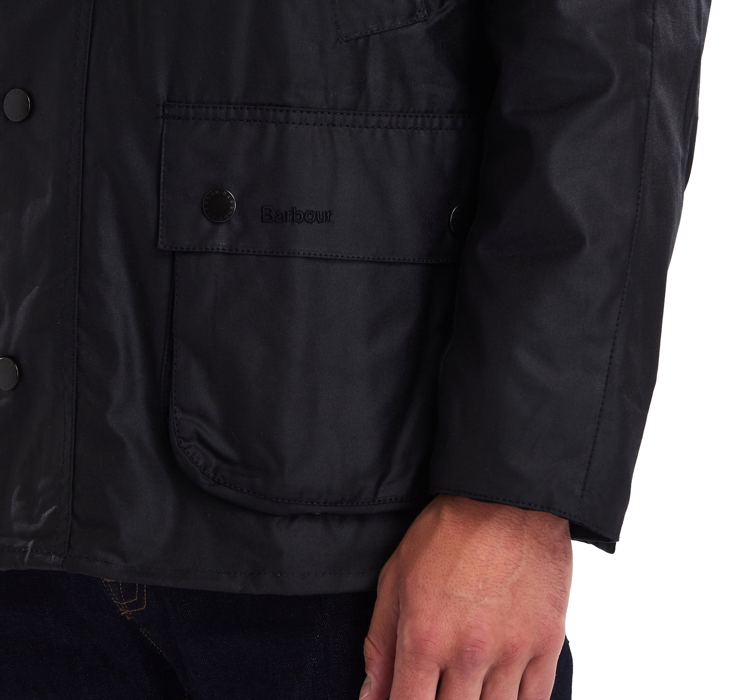 Front pocket of a Barbour Ashby waxed jacket in black.